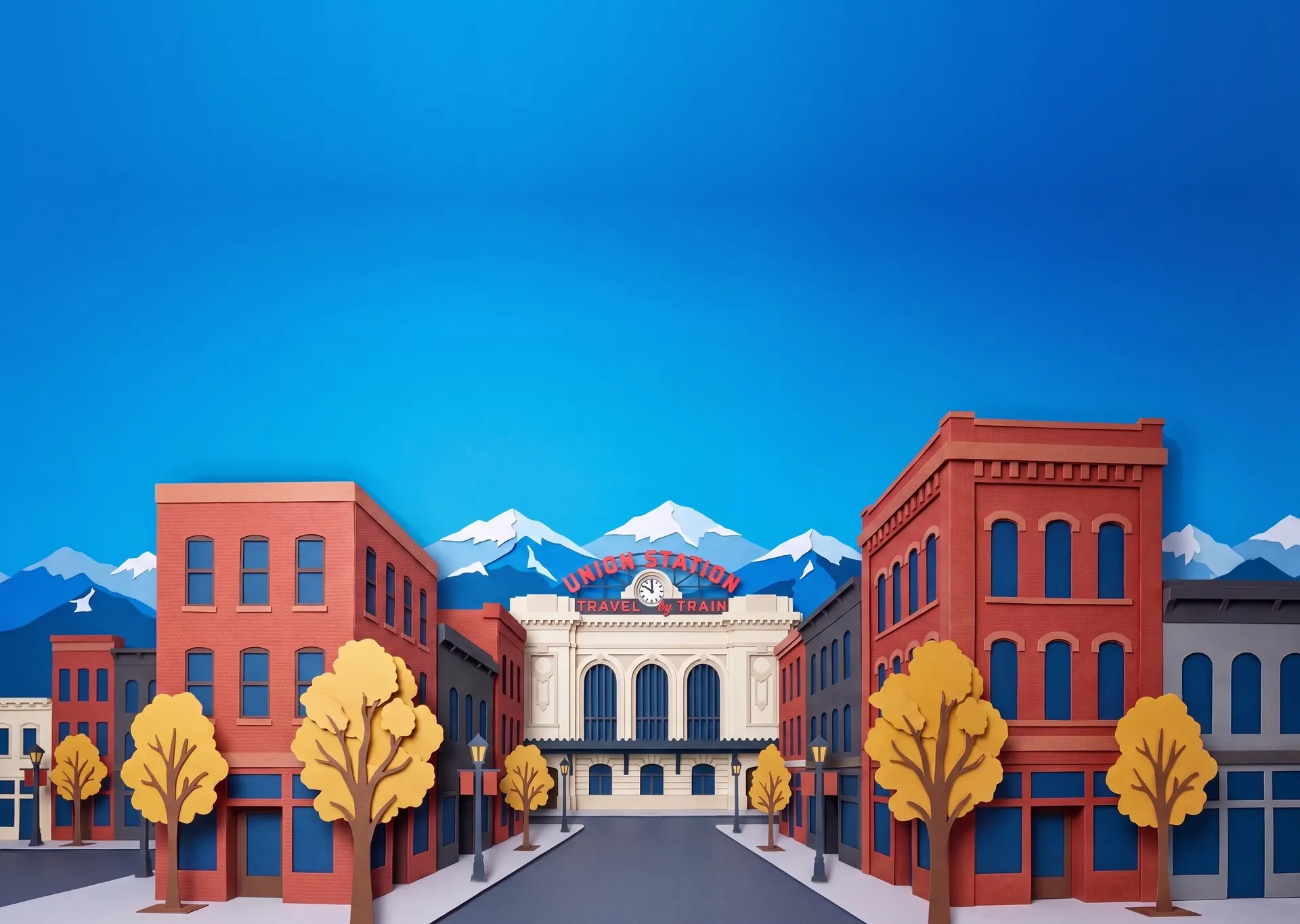 Cut-paper Denver: Union Station and brick buildings with golden October trees, the Rocky Mountains behind.